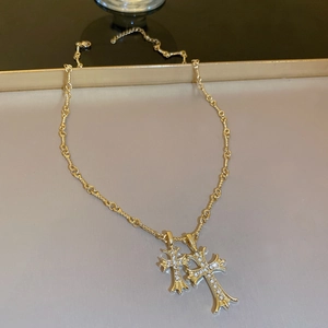 Macro detail of gold plated double cross pendants with sparkling zircon stone settings