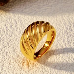 Macro view of gold croissant ring with spiral textured surface and polished finish