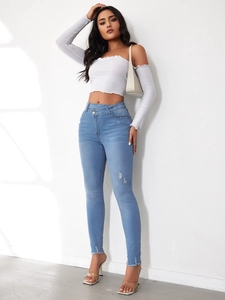 Detailansicht der hellblauen High-Waist-Slim-Jeans mit weißem schulterfreiem Langarm-Top