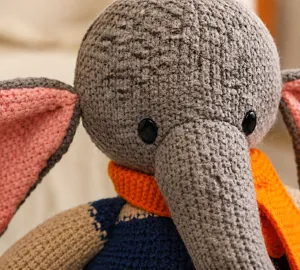 Détail de la peluche éléphant tricotée main avec laine grise et écharpe orange