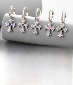 Detailed view of silver hoop earrings with vintage zircon crosses in multiple colors