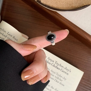 Detailed close-up of a vintage S925 silver ring with black onyx on a female hand