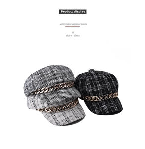 Three plaid newsboy caps with gold metal chain trim in black, grey and white