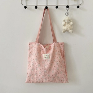 Detail of pink bubble crepe tote bag with rabbit patterns hanging on a metal hook