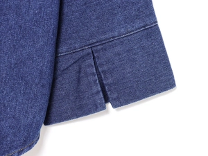 Dettaglio ravvicinato del tessuto denim blu scuro con orlo spaccato e doppia cucitura precisa