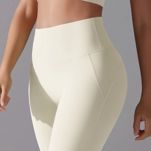 Detail of high-waisted cream yoga leggings with ergonomic booty lifting seams and soft fabric