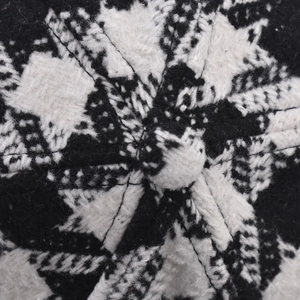 Macro shot of thick black and white plaid knit baseball cap with top button detail