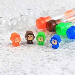Close-up of colorful cartoon monkey shaped pencil toppers in blue, orange, and green