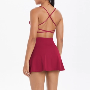 Détail d'un ensemble de yoga bordeaux avec brassière à dos croisé et jupe de tennis plissée