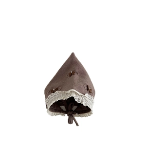 Nordic knit baby bonnet with lace trim and bow accents in warm brown winter style