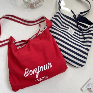 Vue détaillée de sacs cabas en toile à rayures rouges et marine avec imprimé Bonjour