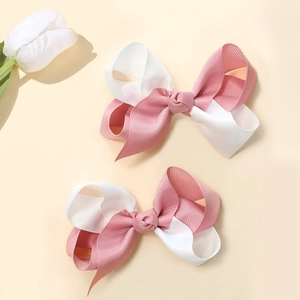 Détail de pinces à cheveux avec nœuds en ruban gros-grain rose et blanc pour filles