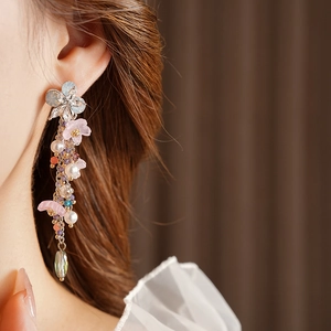 Orecchini pendenti a fiori con perle e cristalli su modella in uno stile vintage