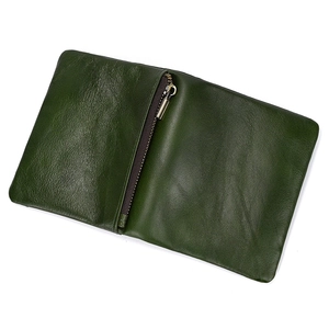 Detailed close-up of green genuine leather texture on a folding wallet with metal zipper