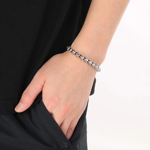 Detail of silver square link chain bracelet showing high-polished finish on wrist