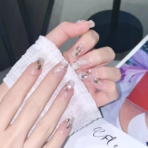 Pink sheer press-on nails with 3D butterfly wings, glitter, and rhinestone details