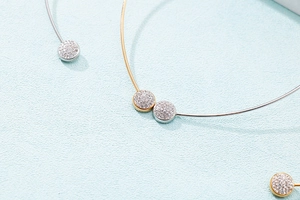Detail of minimalist gold and silver rings with sparkling pave-set circular decorations