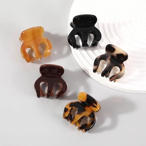Detailed view of small acetate claw clips in five assorted shell and amber colors