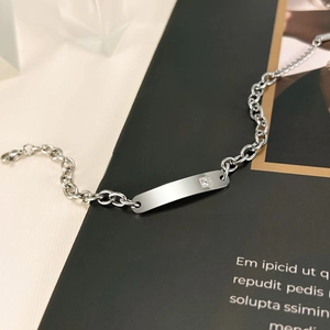 Detailed close-up of a silver stainless steel ID chain bracelet with a square zircon stone