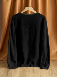 Detail showing the breathable linen-cotton fabric and dark green trim on a black shirt