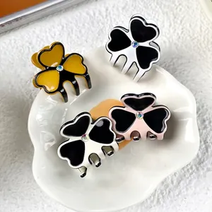 Set of four small acetate clover hair claws with rhinestones in multiple colors