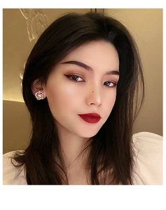 Close-up of elegant double-layered pearl and diamond earrings worn by a model