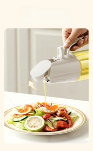 Vue détaillée du distributeur d'huile en verre versant de l'huile sur une salade fraîche