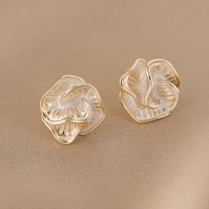 Elegant gold-edged white camellia pearl stud earrings on a premium silk background