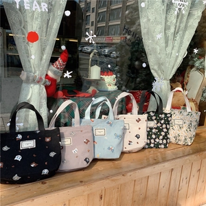 Detail showing various embroidered floral and cat patterns on canvas hand bags