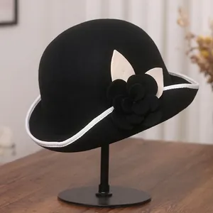 Elegant black wool felt cloche hat with camellia flower detail and white trimmed brim
