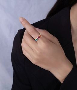 Détail d'une bague en argent 925 avec pierres multicolores arc-en-ciel portée au doigt