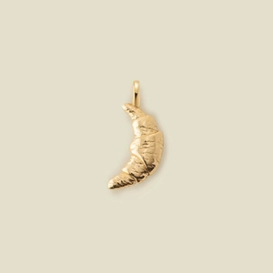 Detailed macro shot of a textured golden croissant pendant with a sturdy top jump ring