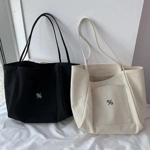 Detail view of large canvas tote bags in black and beige with iconic percent logo