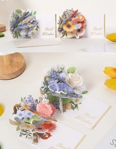 Detailed close-up of 3D watercolor floral pop-up cards with gold Best Wishes engraving
