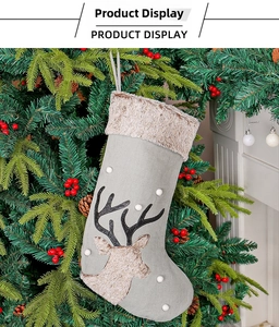 Detail of Christmas stocking with reindeer silhouette and 3D pompoms near fireplace