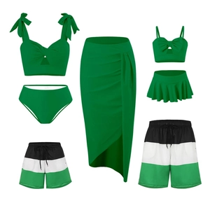 Matching family swimwear set with green and striped bikini, skirt, and swim trunks