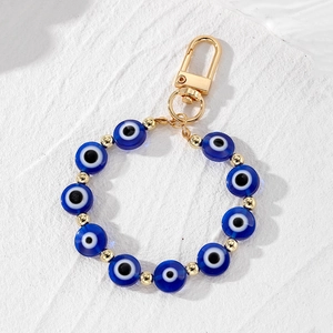 Detail of blue evil eye beads with golden spacers and a sturdy lobster clasp keychain