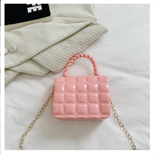 Detailed view of pink quilted PVC jelly bag with woven handle and gold chain strap