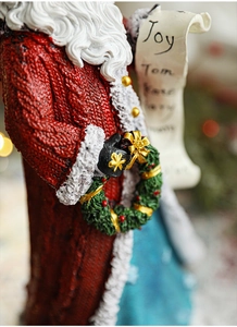 Macro view of Santa figurine with detailed knit texture and festive Joy wreath