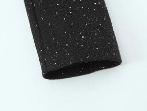 Detail of black tweed sleeve cuff with silver sequins and woven metallic texture