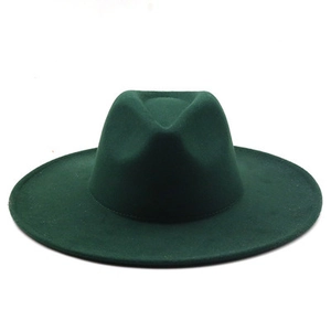 Flat lay of a dark green wide brim fedora hat in vintage wool felt material for winter