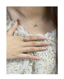 Close-up of S925 silver necklace with green jade pendant worn on a lace outfit