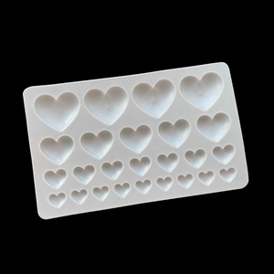 Macro detail of white heart-shaped silicone mold with 28 cavities for DIY chocolate cake decor