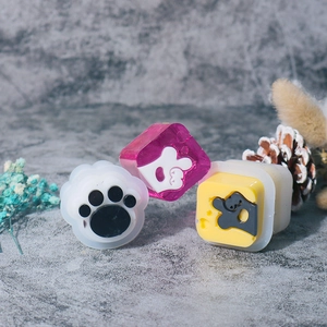 DIY cat paw and hand gesture resin molds set on a grey background with decorative props