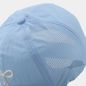 Macro detail of breathable mesh texture and bow ornament on quick-dry sun hat