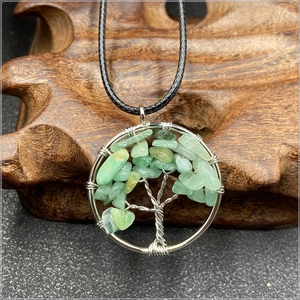 Macro detail of Tree of Life pendant with green stones and intricate silver wire wrapping