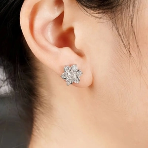 Detailed view of shimmering cubic zirconia flower earrings worn on the earlobe