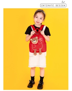 Detail of red toddler backpack with plush 3D bear design and very happy print