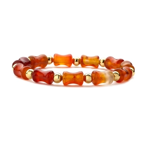 Detailed view of orange agate bamboo beads and golden spacers on the beaded bracelet