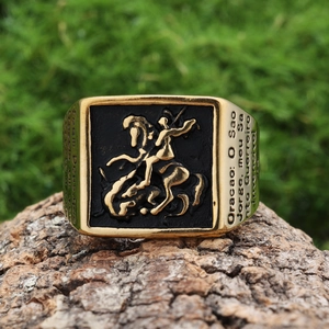 Gros plan d'une bague de chevalier St George avec relief doré sur fond noir et écorce